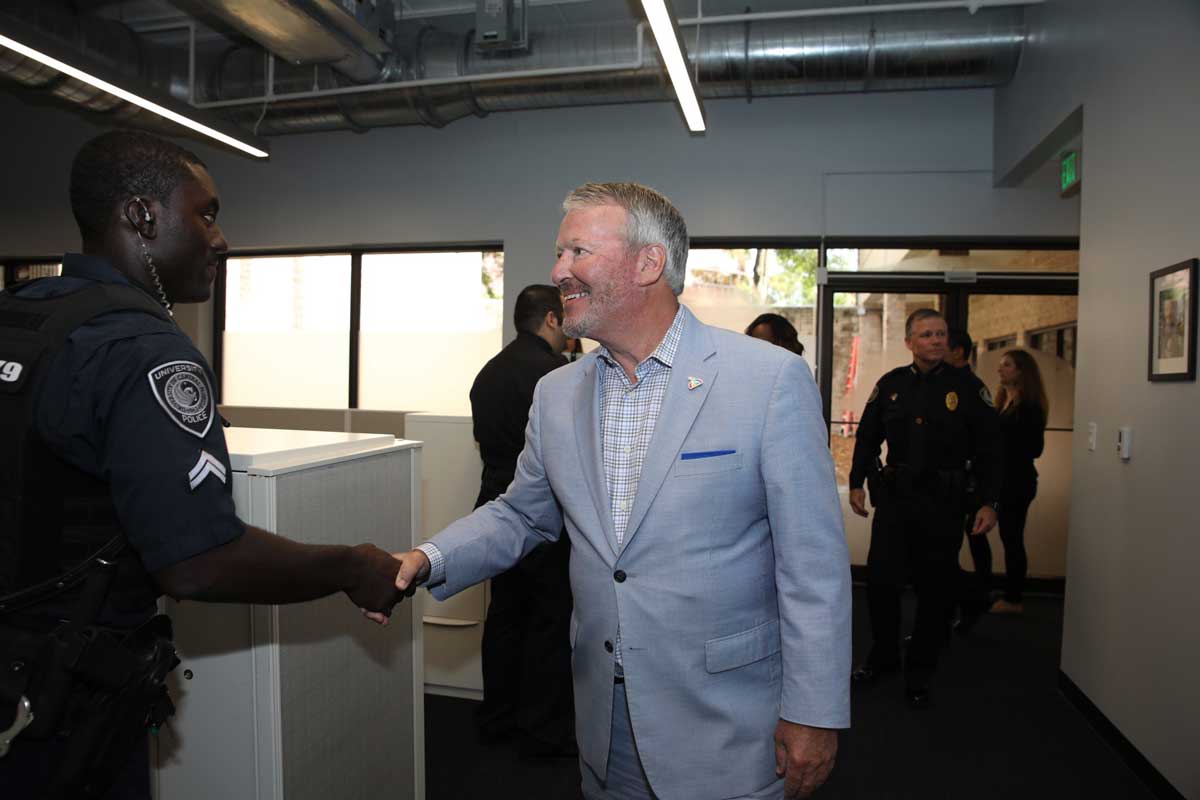 City of Orlando Mayor Buddy Dyer shakes hands with police officer in downtown station