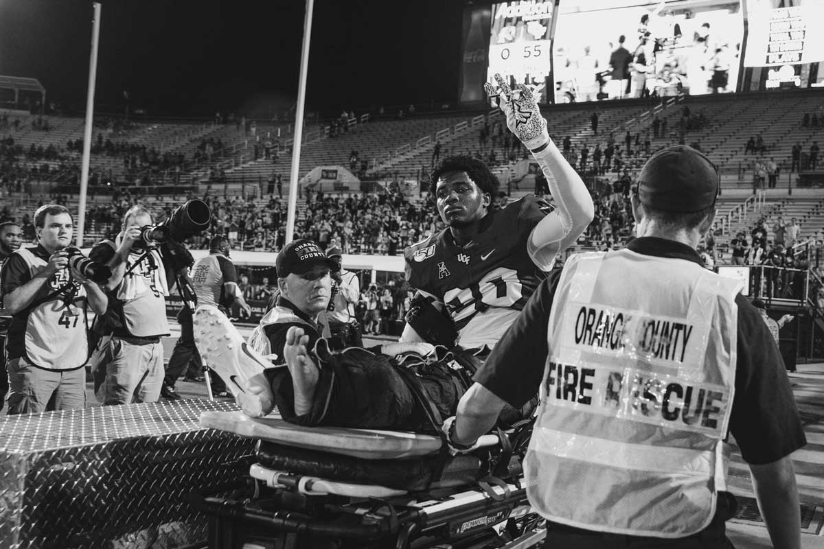 cornerback Brandon Moore waves to crowd as he is carted off the field