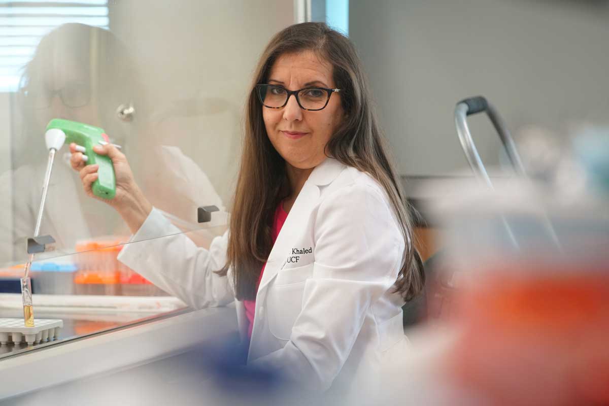Annette Khaled wearing a white coat in a lab