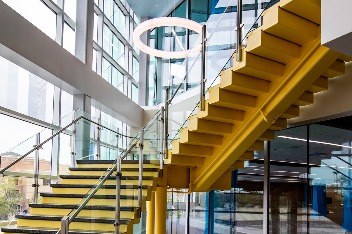 Yellow stairs with glass floor to ceiling windows surrounding them