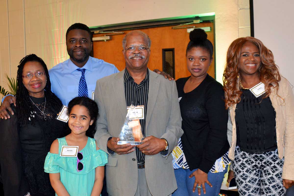 Members of the Williams family with Roland in center holding an award