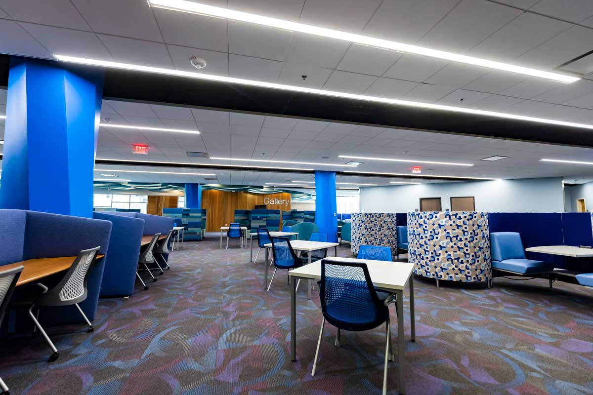 tables and chairs on an open floor with a wood-panel wall in the background named "gallery"