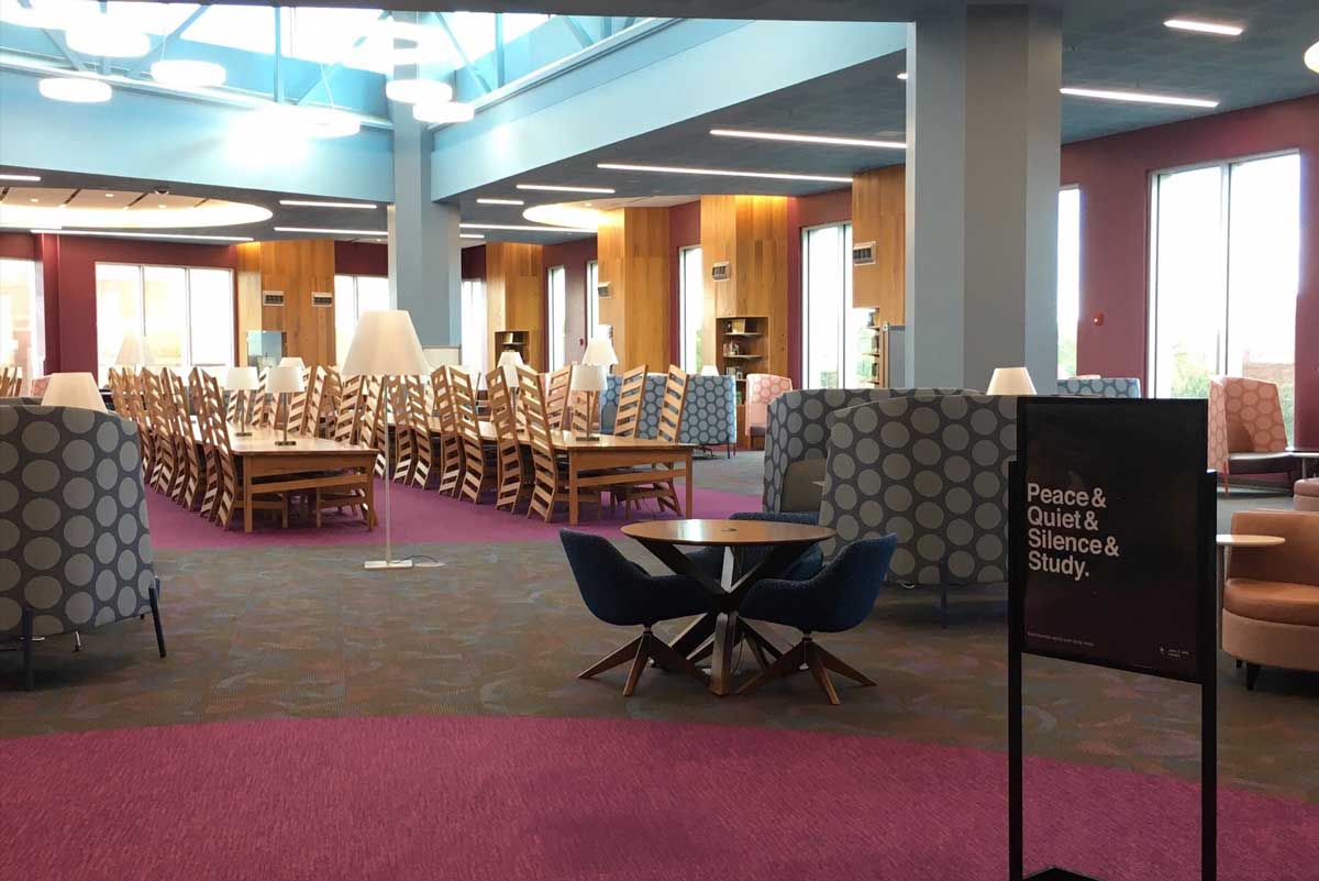 long tables with chairs and a sign that says silence