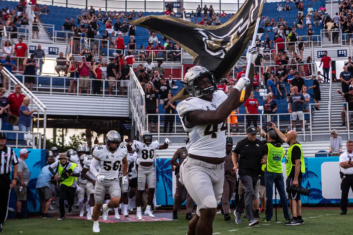 Nate Evans leads team out of the tunnel by holding the UCF flag