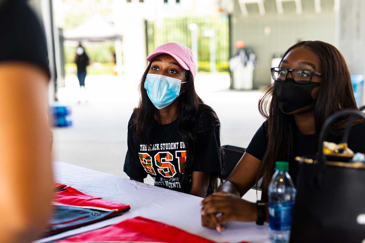 UCF senior Oteisha Barrett sits at a table while wearing a blue face mask