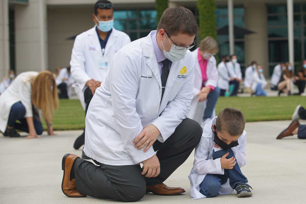 Man knees next to small boy