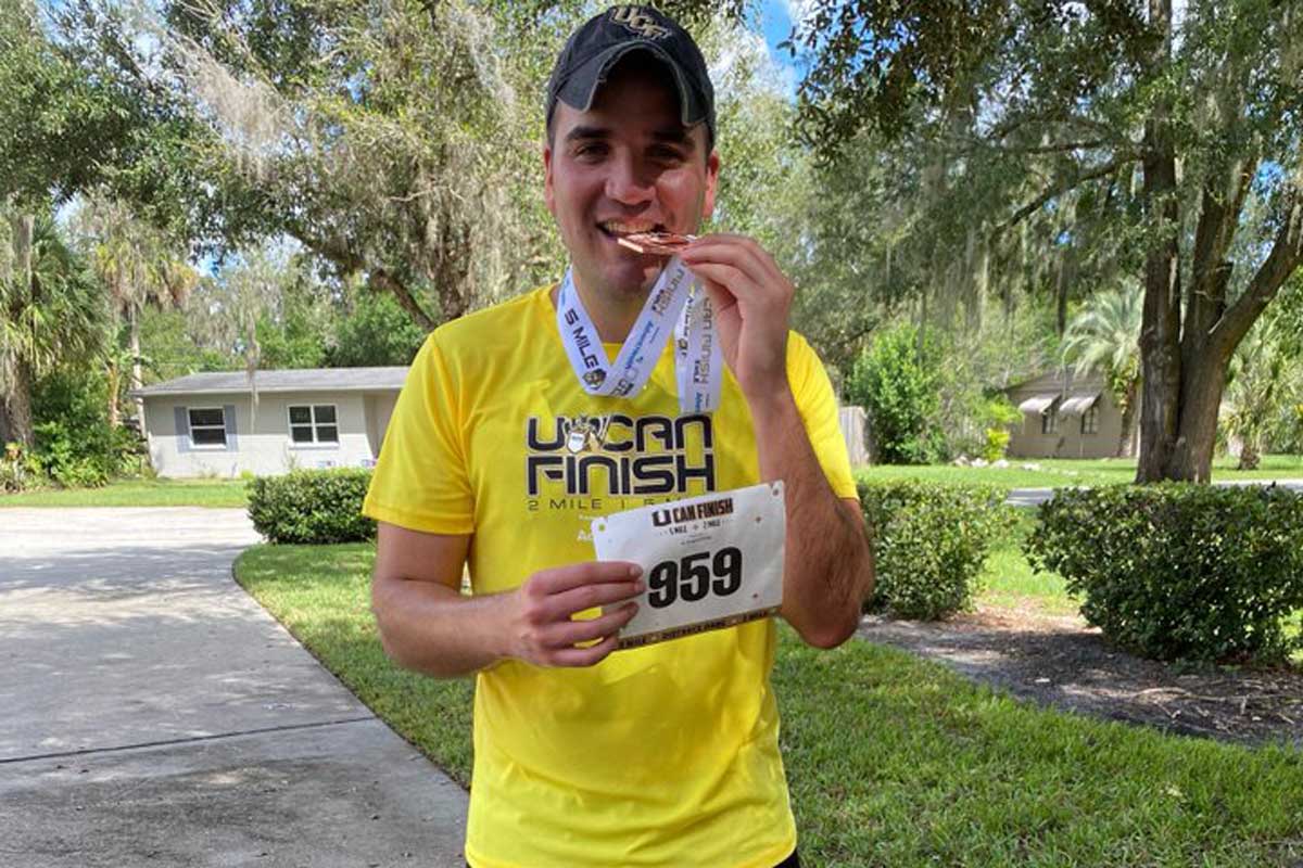 Juan Escobar bites race medal