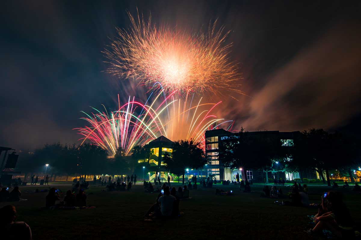 fireworks light up over parking garage on campus