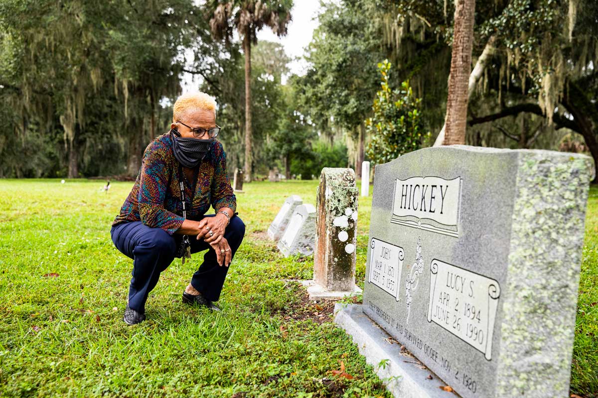 Francina Boykin kneels at tombstone of Hickey