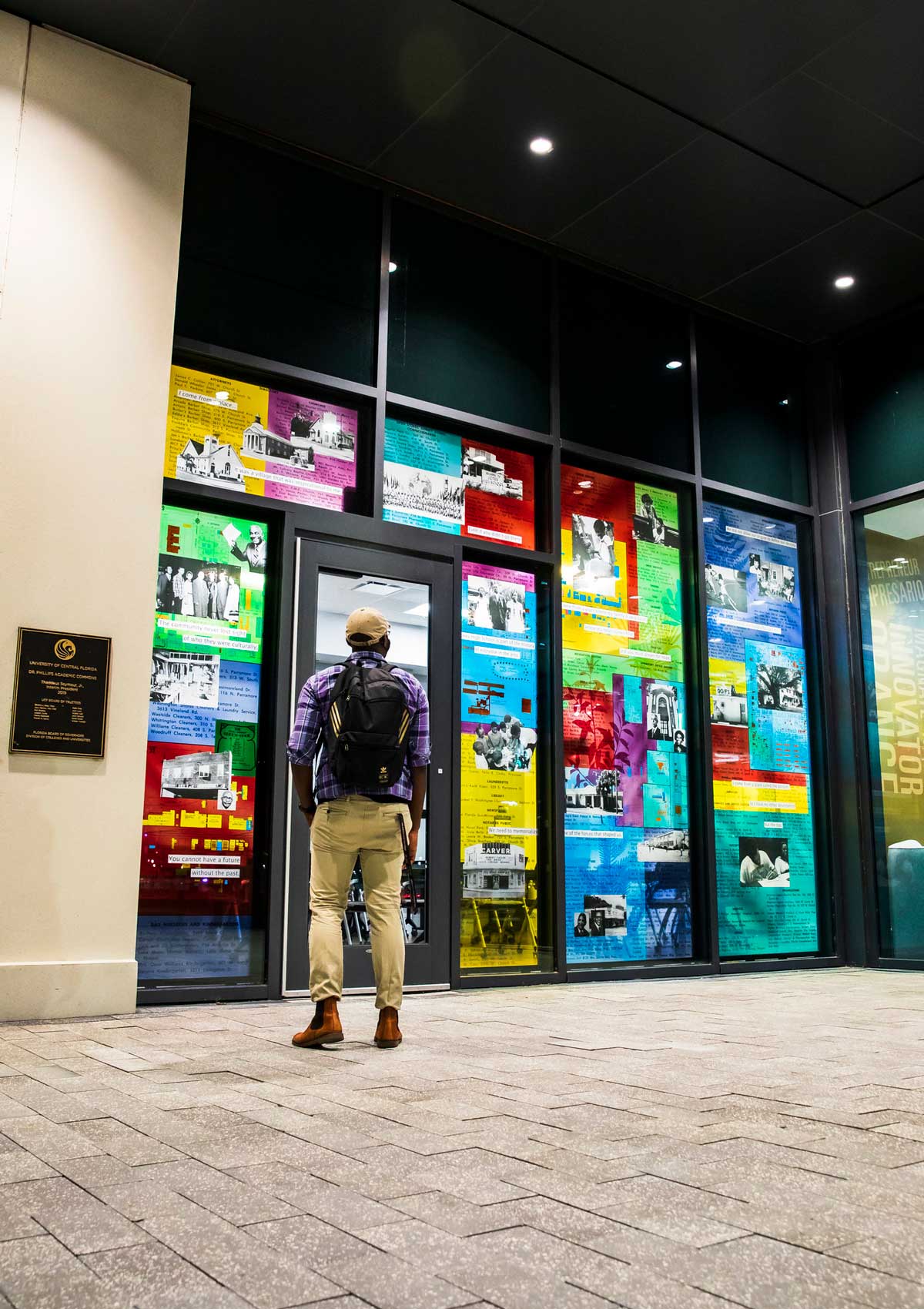 Man admires glass artwork of Parramore Room at UCF Downtown building