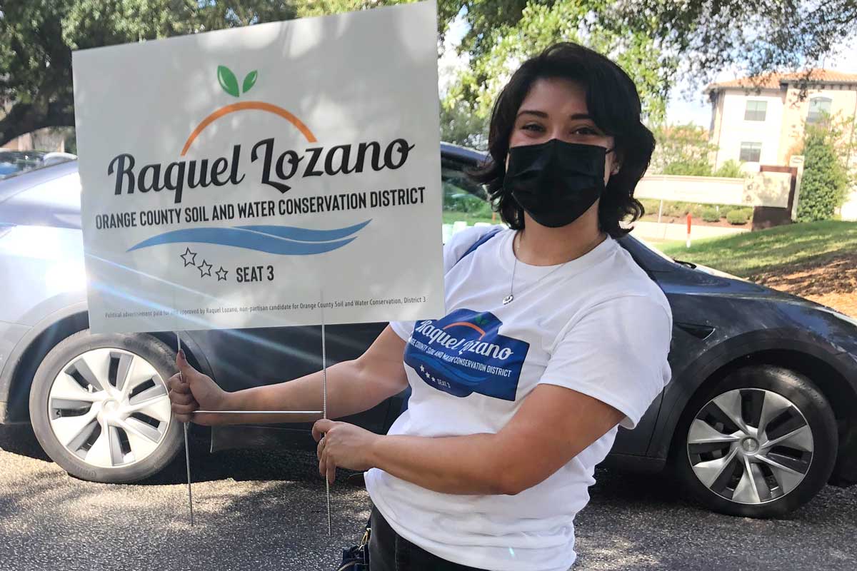Raquel Lozano holds campaign sign 