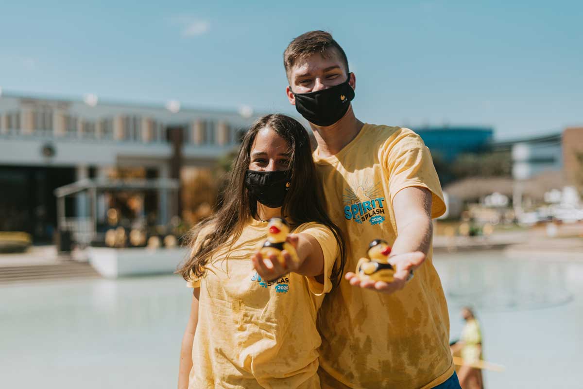 Two students hold out their spirit splash ducks