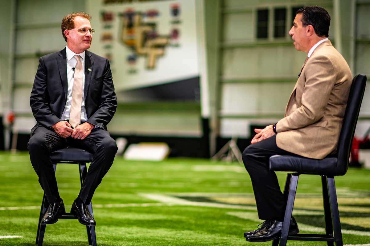 Marc Daniels and Gus Malzahn sit to have a conversation inside the Indoor football practice facility 