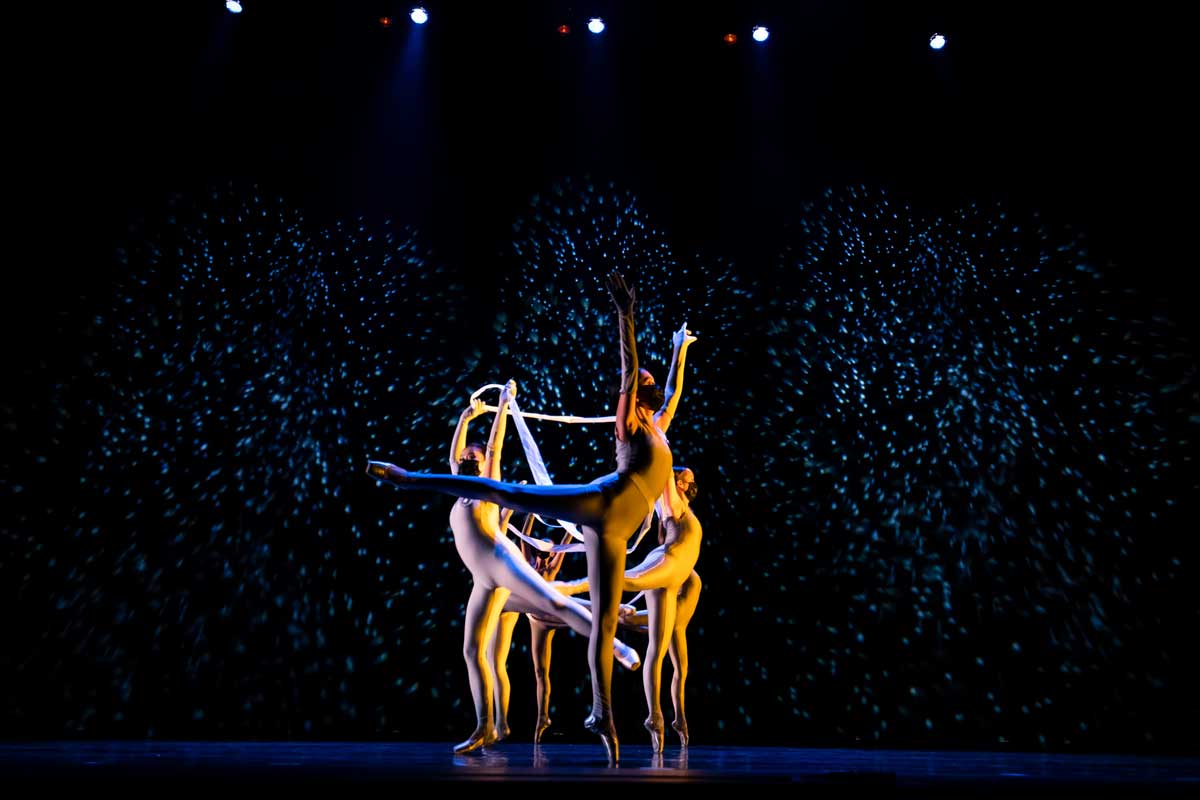 Group of ballet dancers pirouette on stage