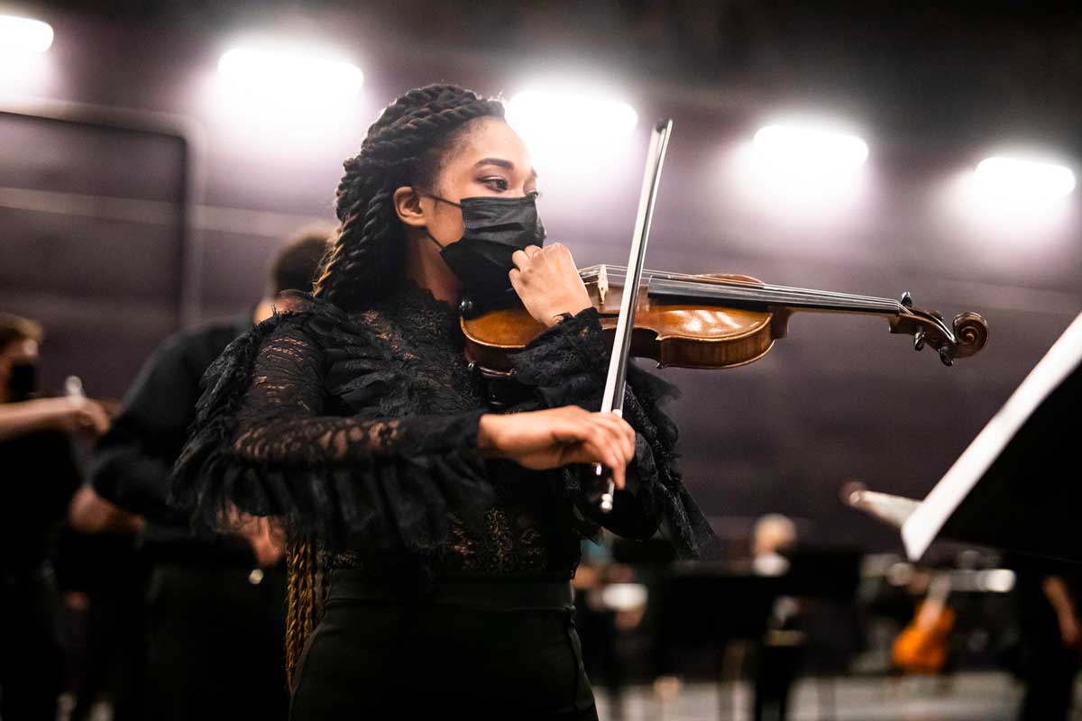 Black woman raises bow to violin 