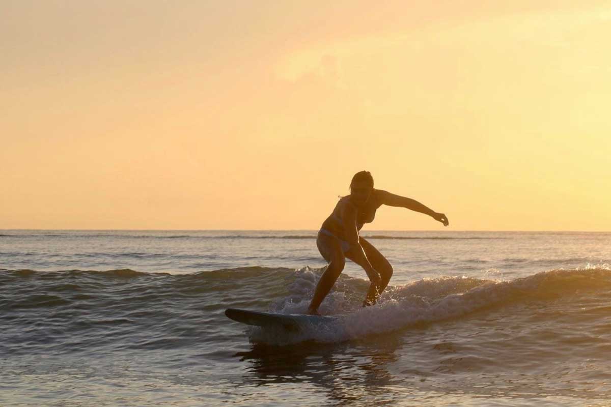 Woman surfs at dawn