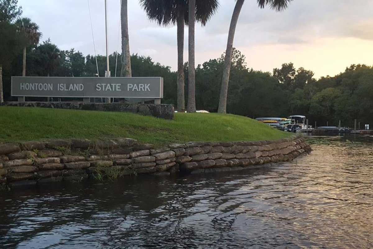 Hontoon Island State Park sign on grass near water