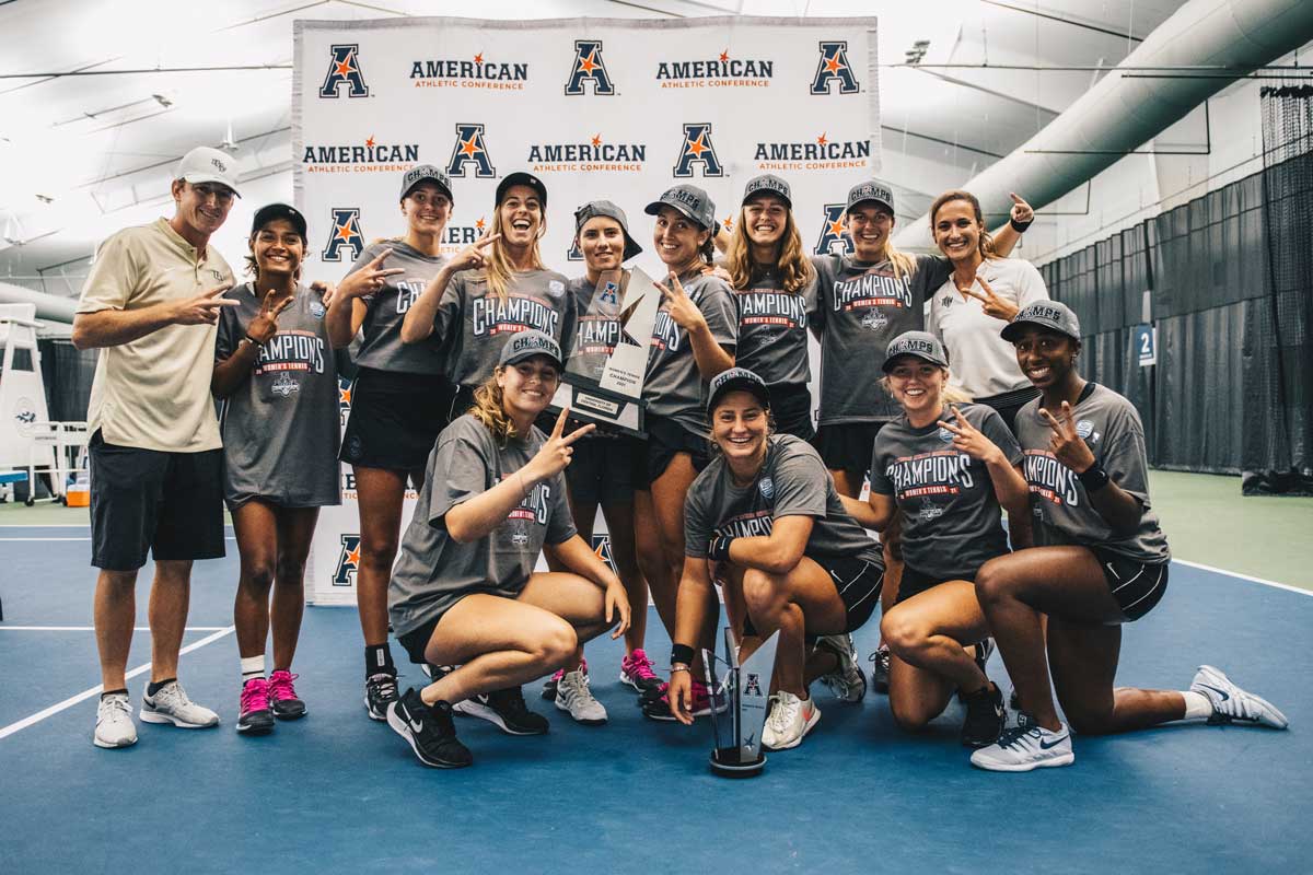 UCF women's tennis team holds two trophies on court