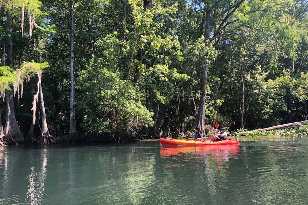 Kayakers in a red kayak launch into Weikva River