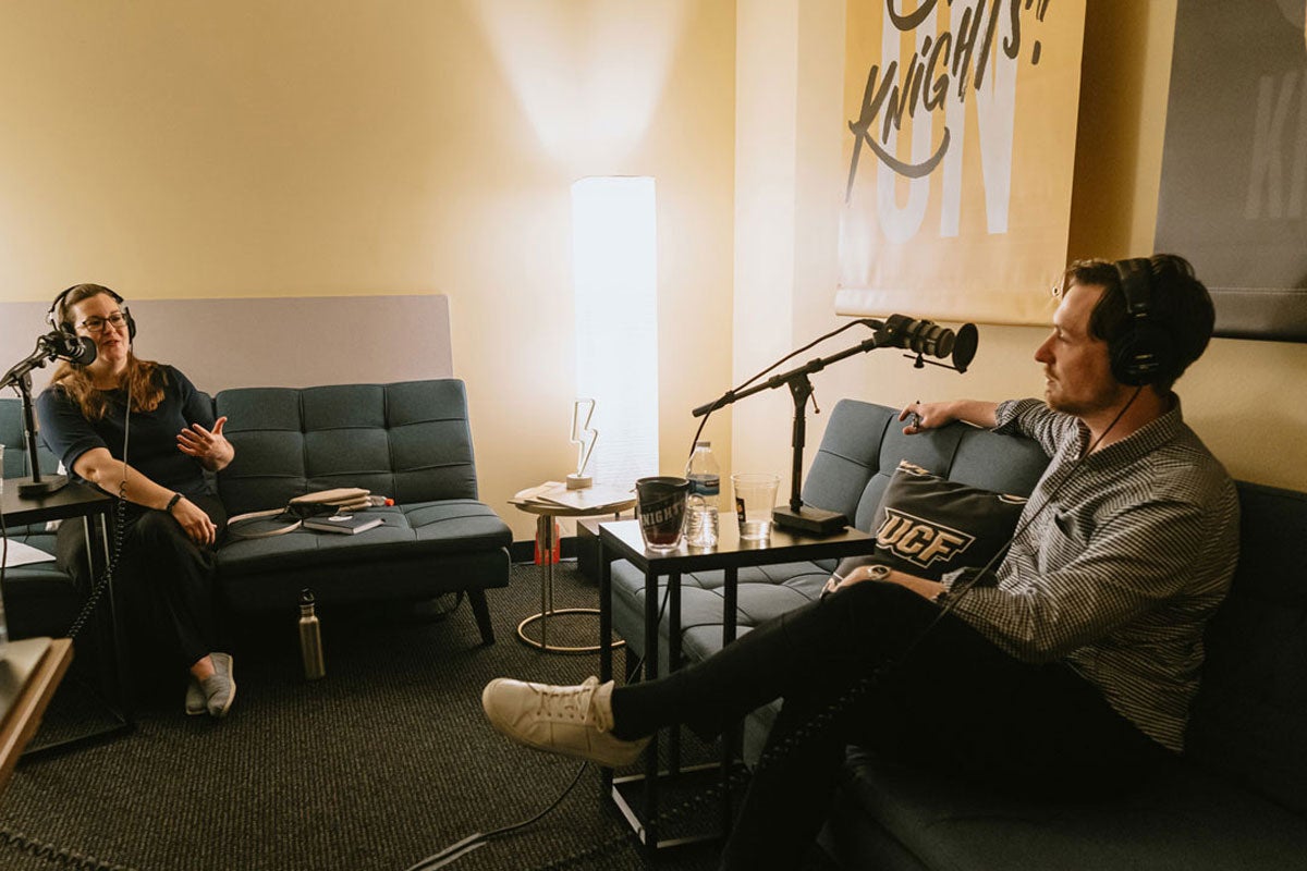 Claire Connolly Knox and Alex Cumming sit on sofas recording podcast