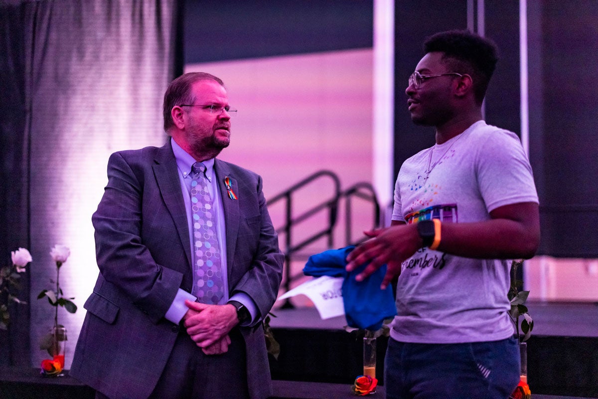 President Catwright speaks with a student in front of the stage