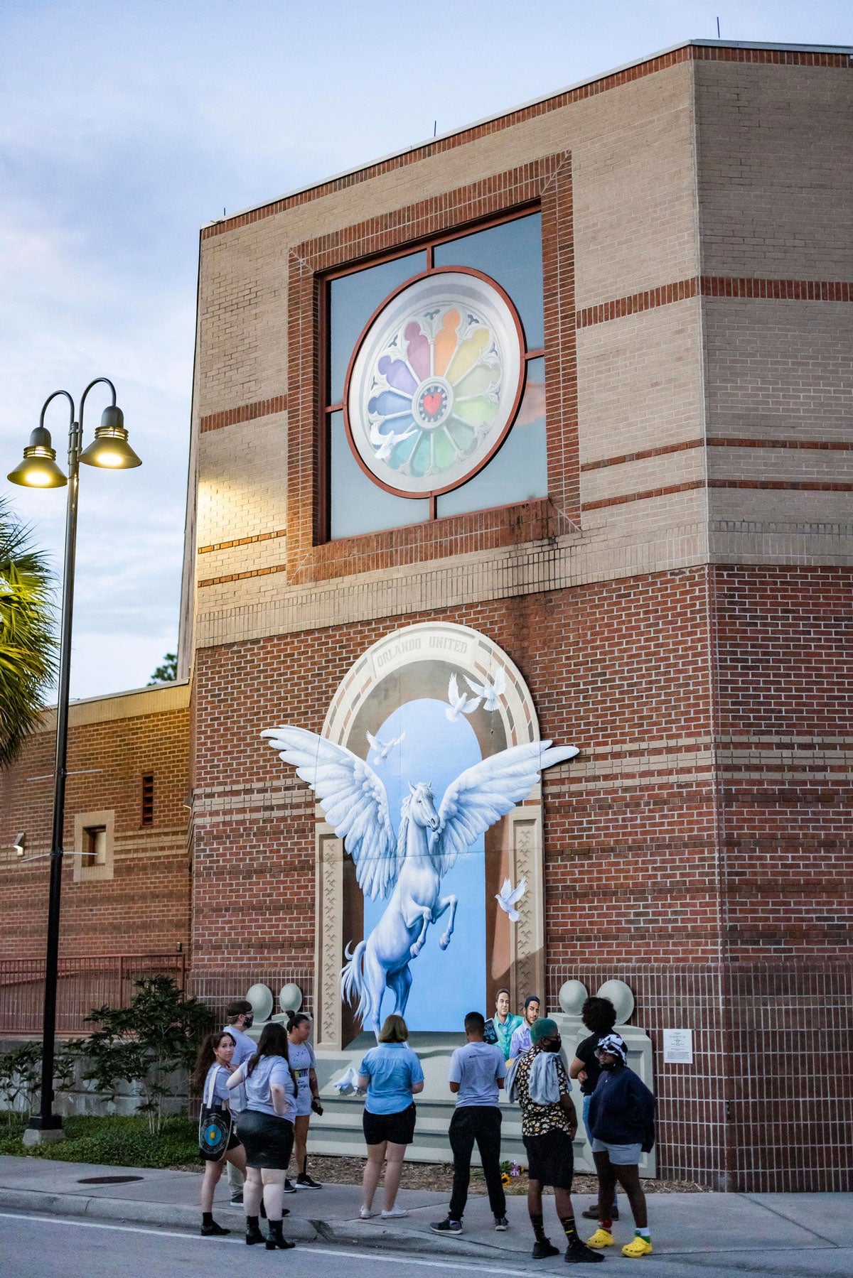 A group of bystanders gazes up at Pulse mural on Student union