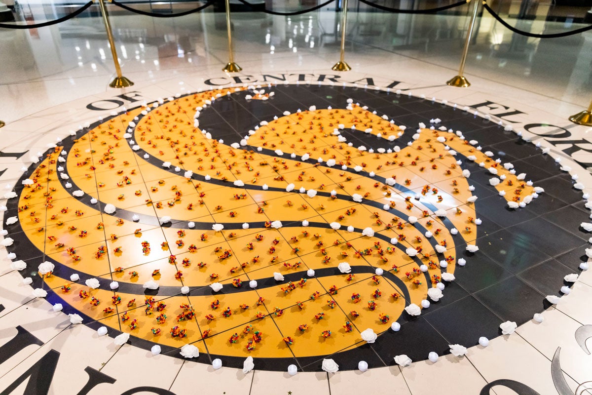 Pegasus seal on the floor of Student Union covered in flowers and candles