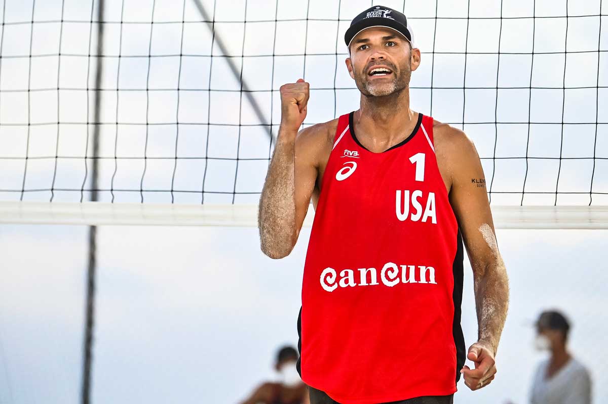 Phil Dalhausser in red jersey clinches fist in front of net