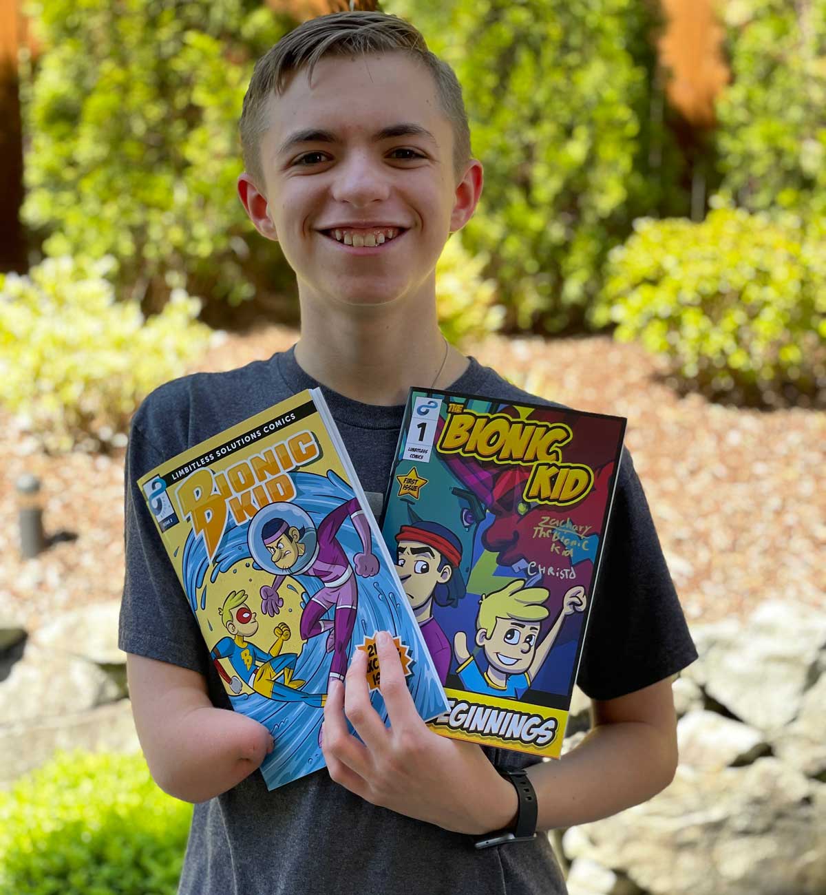 Zachary Pamboukas holds 2 copies of The Bionic Kid