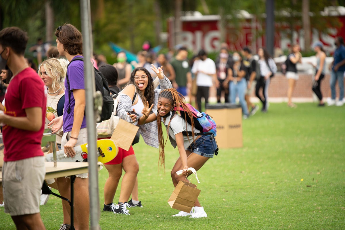 Students pose with funny faces on Memory Mall while people mill about around them