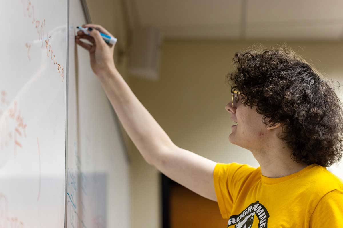 Seba Villalobos works on a white board 