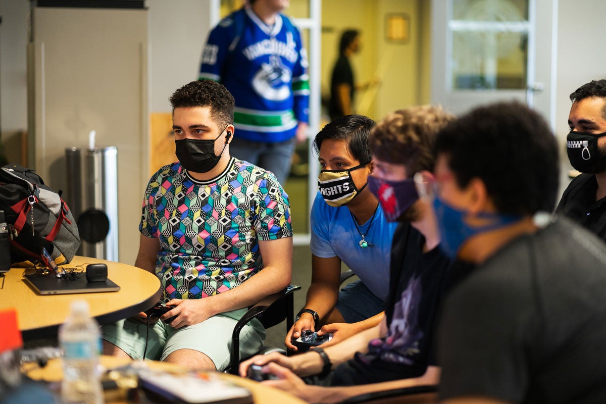 Four students play a video game on third floor of Student Union