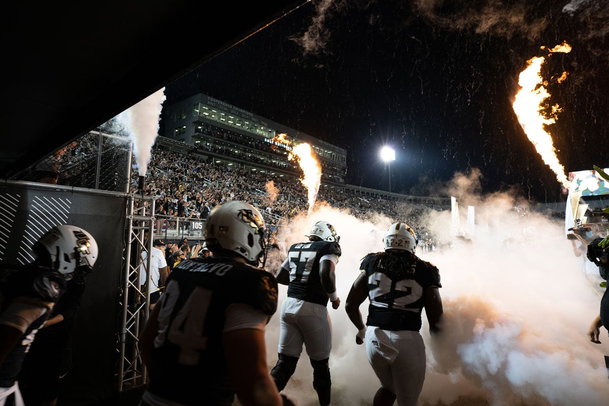 UCF football players leave the tunnel to run out to the field with fireworks shooting off