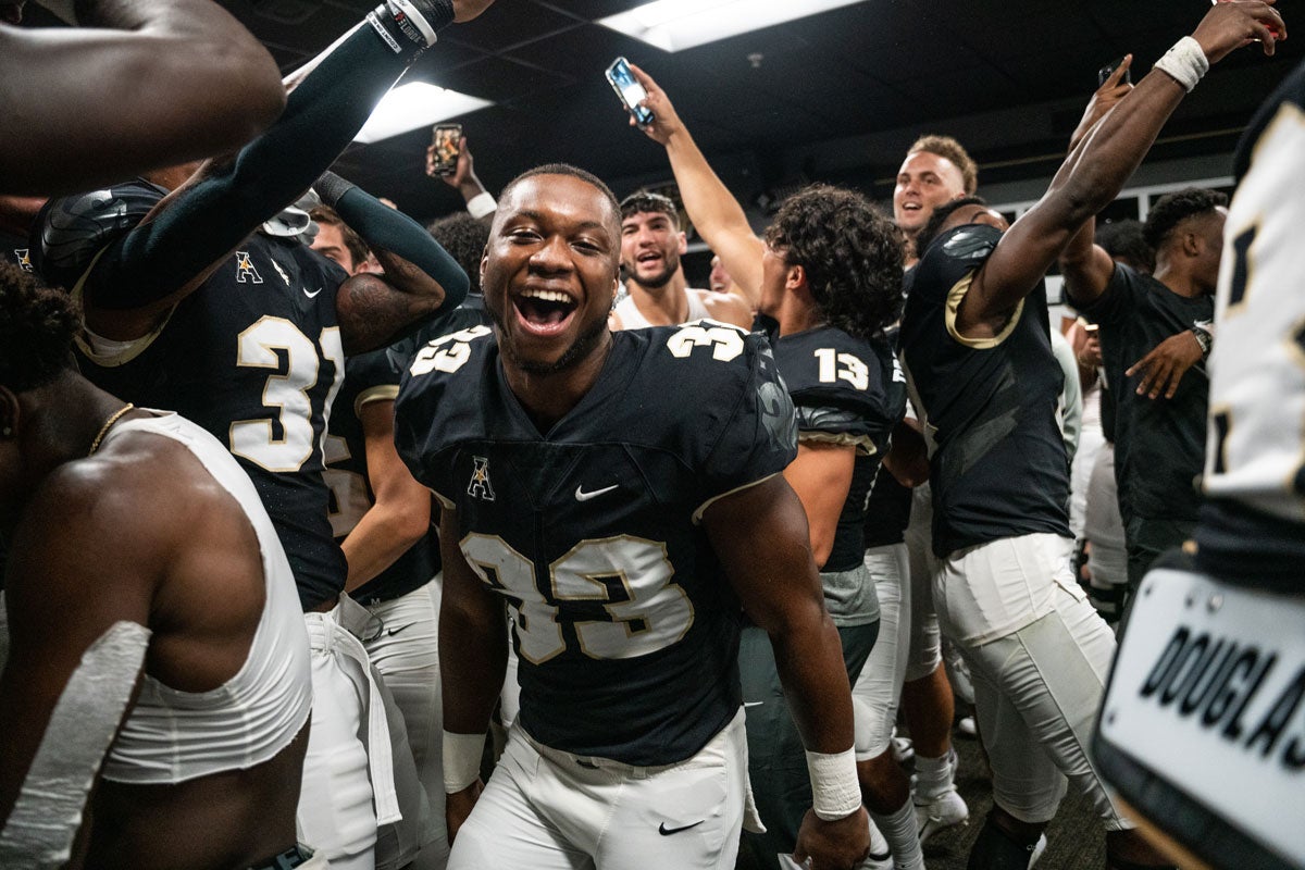 Football players celebrate in the locker room