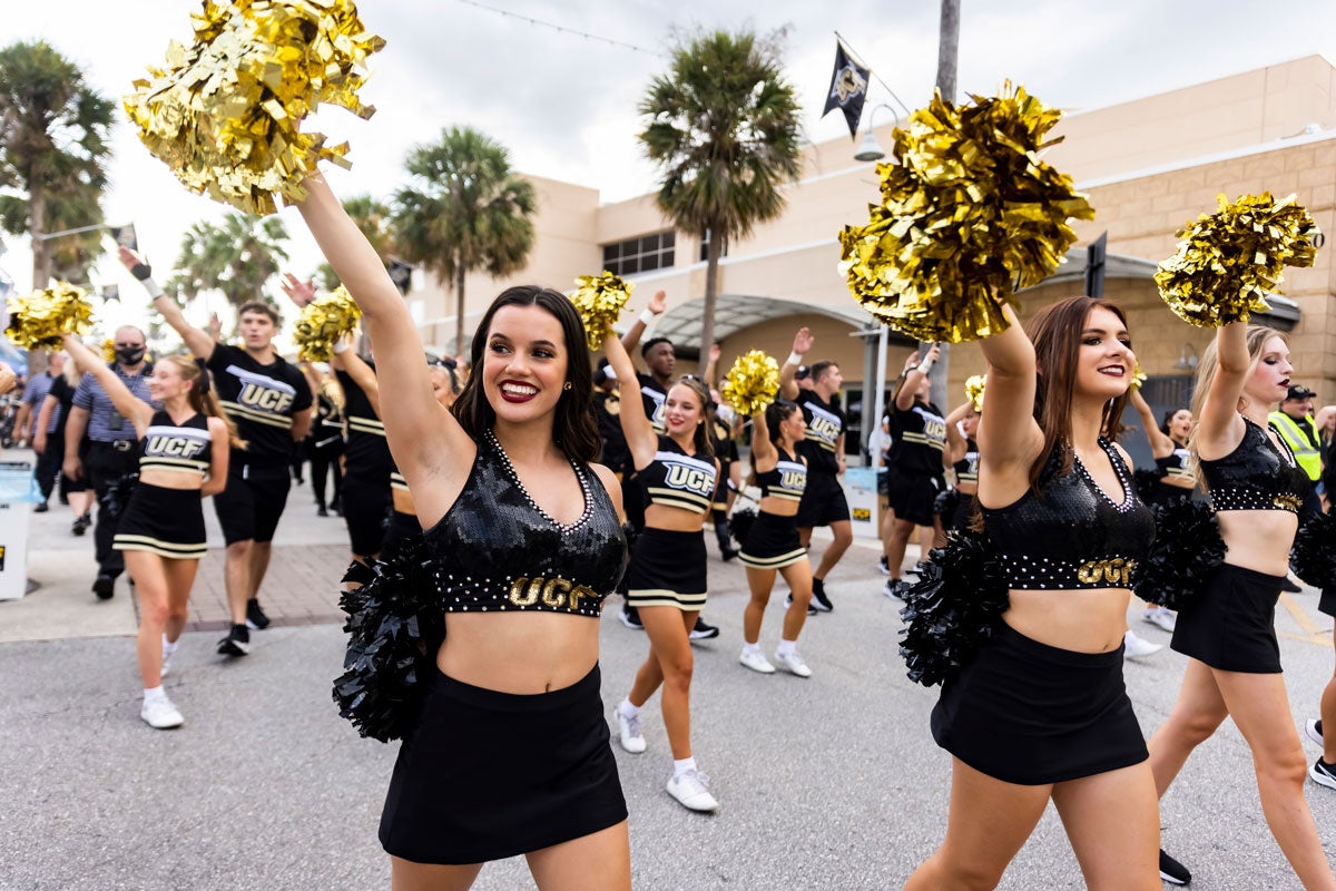 UCF cheerleaders wave pom poms on East Plaza Drive