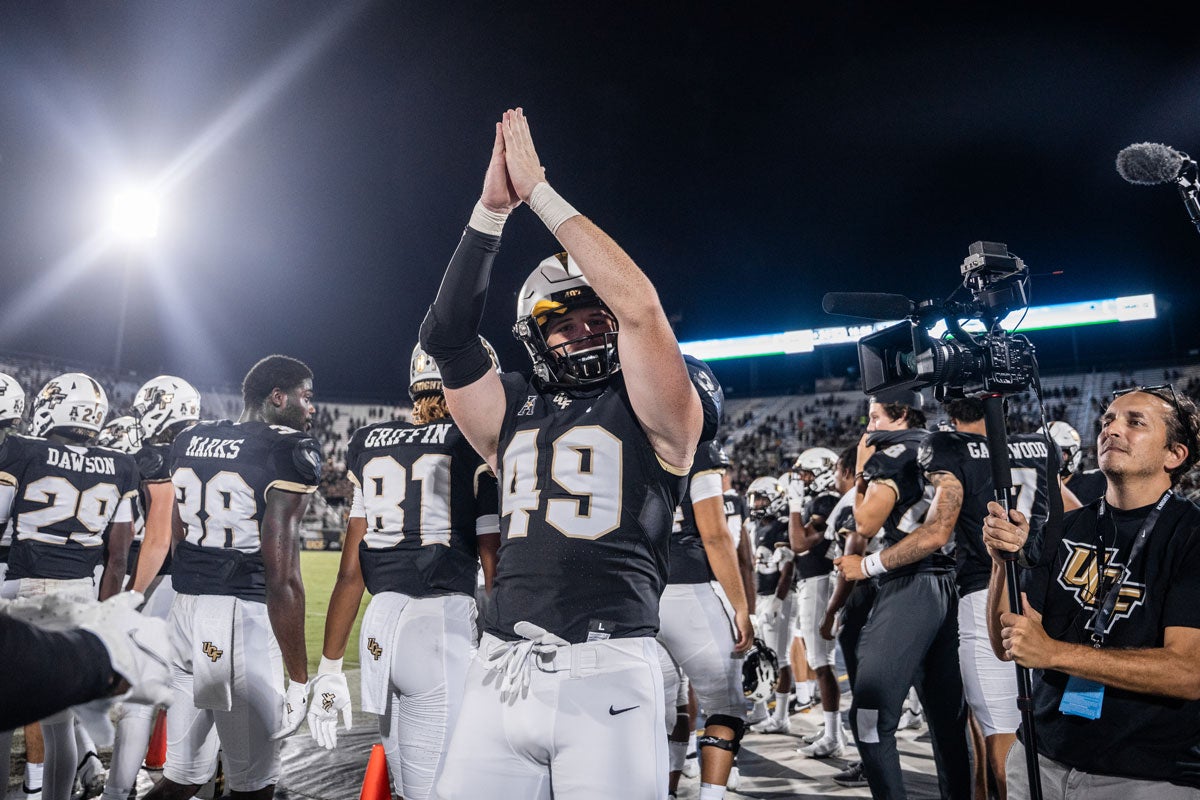 Tight end Max Holler holds up the hand signal for safety on the sidelines