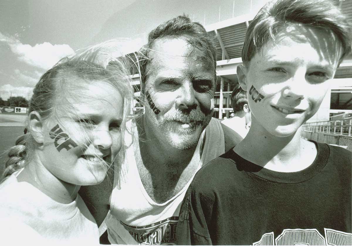 Black and white photo of Dad and two children with faces painted 