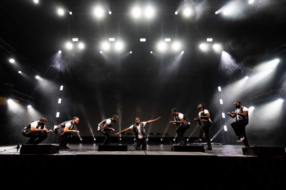 Male students on stage in formation for dance show