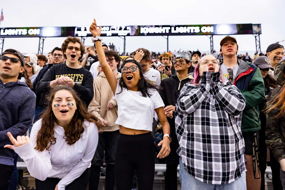 Students in stands at football game cheer