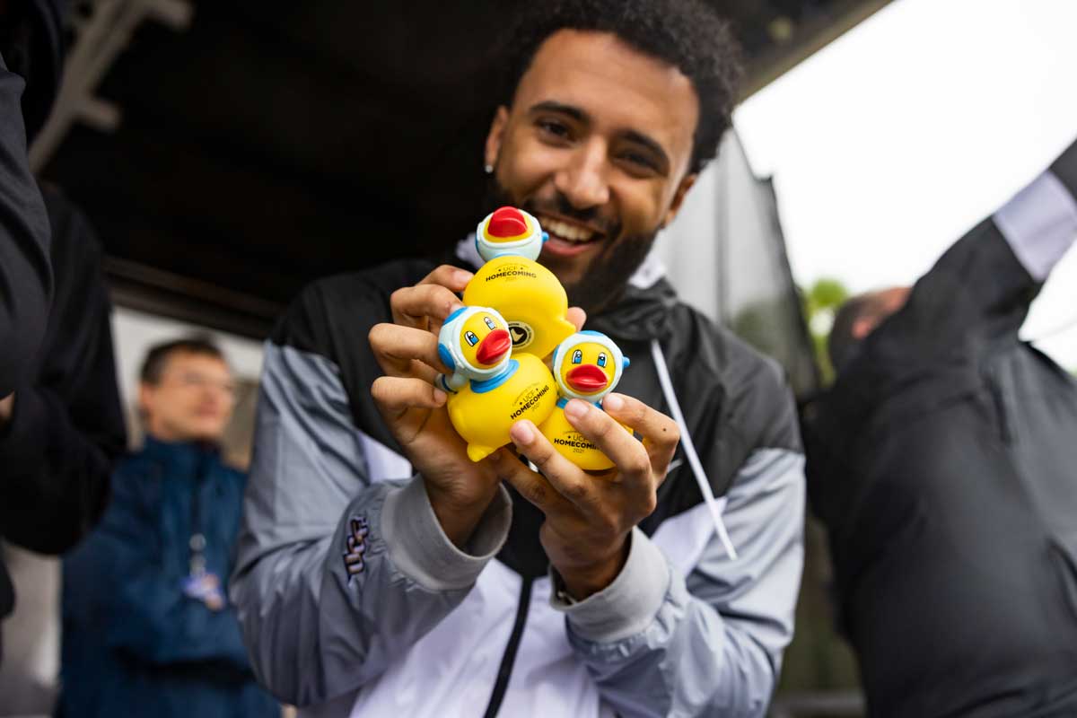 Closeup of man holding three rubber ducks from 2021 Spirit Splash