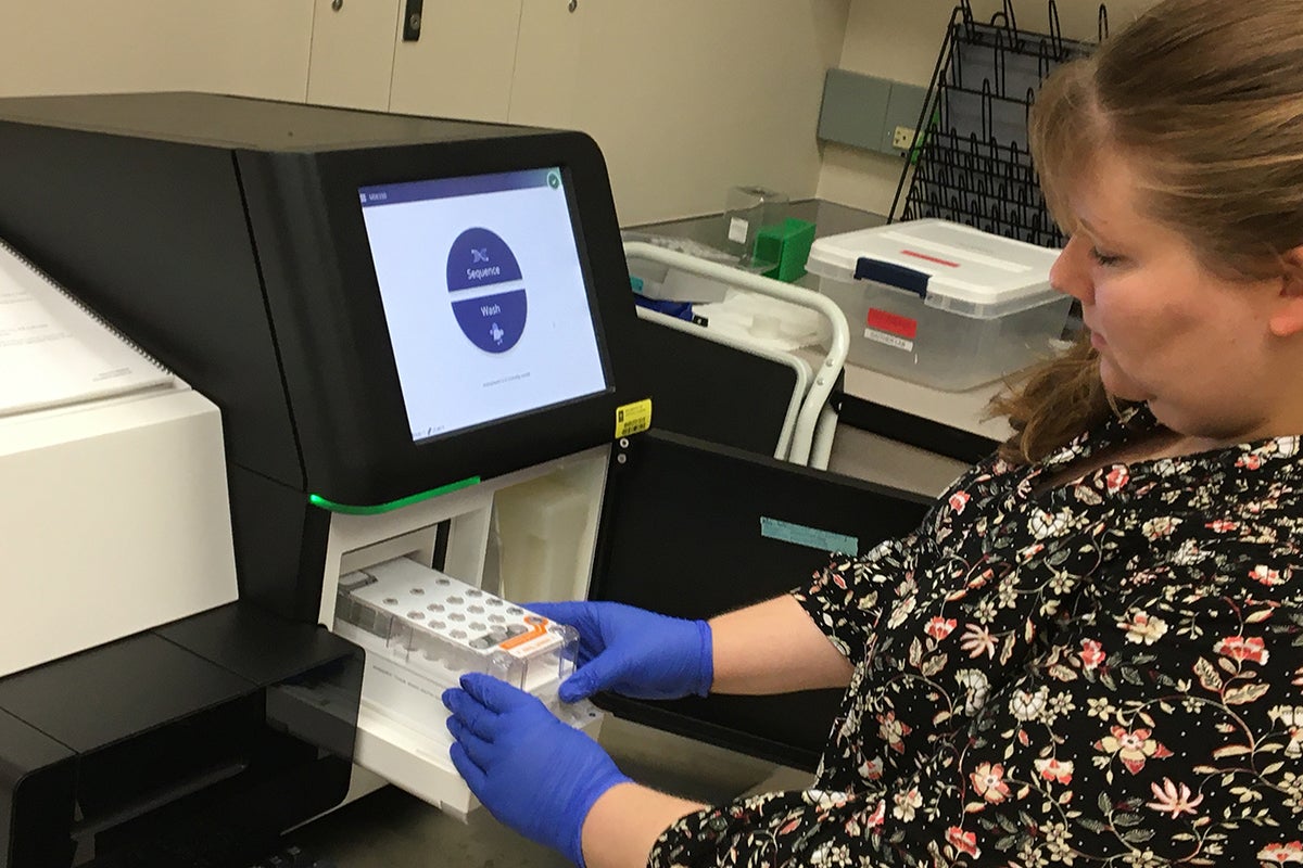 researcher loads a next generation sequencer