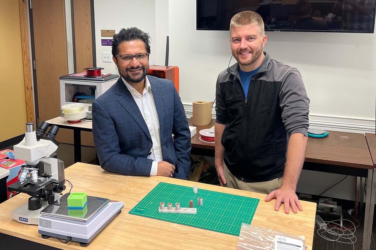 2 researchers standing with the lunar regolith bricks they've created