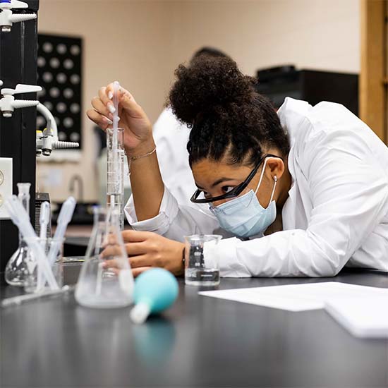 Chemist looks at a flask