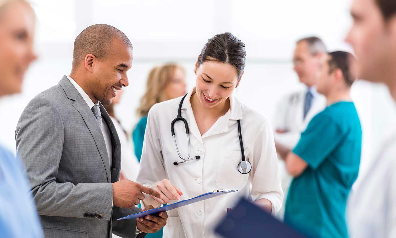 doctor and professional reviewing data points on a clipboard.