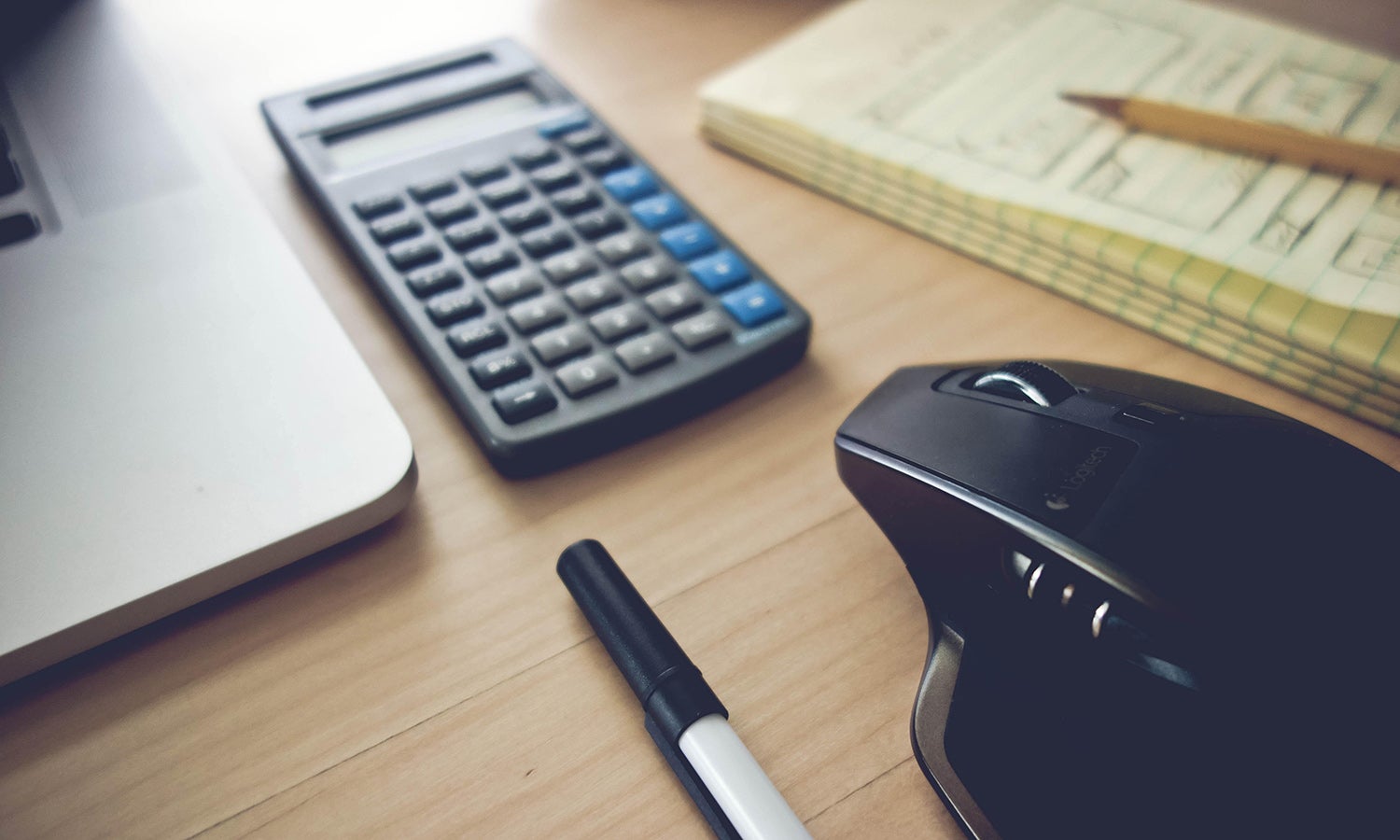 Laptop, pen, calculator, mouse in foreground - notebook & pencil in the background, slightly out of focus. You could make the reasonable assumption that the user of these objects is planning their financial aid strategy. Here's a tip that's not in the article: Don't take out more than you need to pay for school. Most living and entertainment expenses should not be dependent upon receiving financial aid.