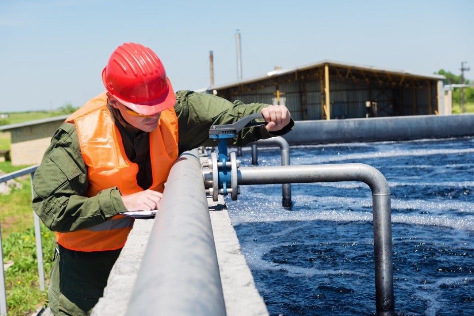 Water resource engineer adjusts treatment pump.