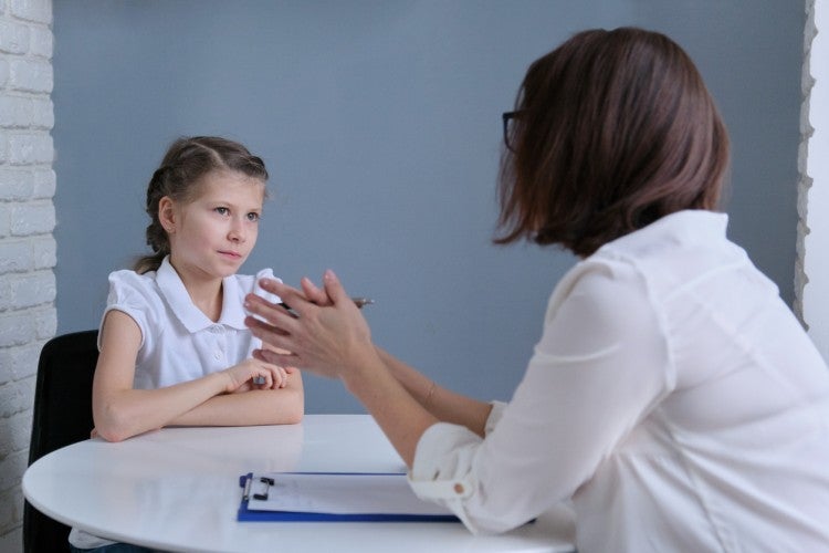 A school social worker meets with a young student in her office.