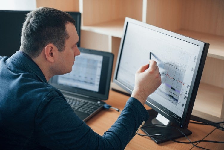 A man studies information on a computer screen.