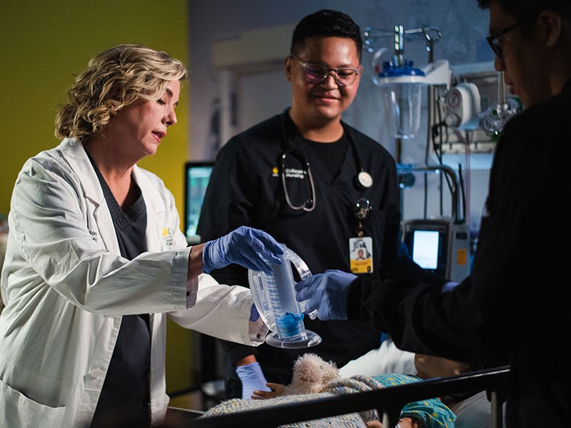 Nursing instructor looking over a breath device