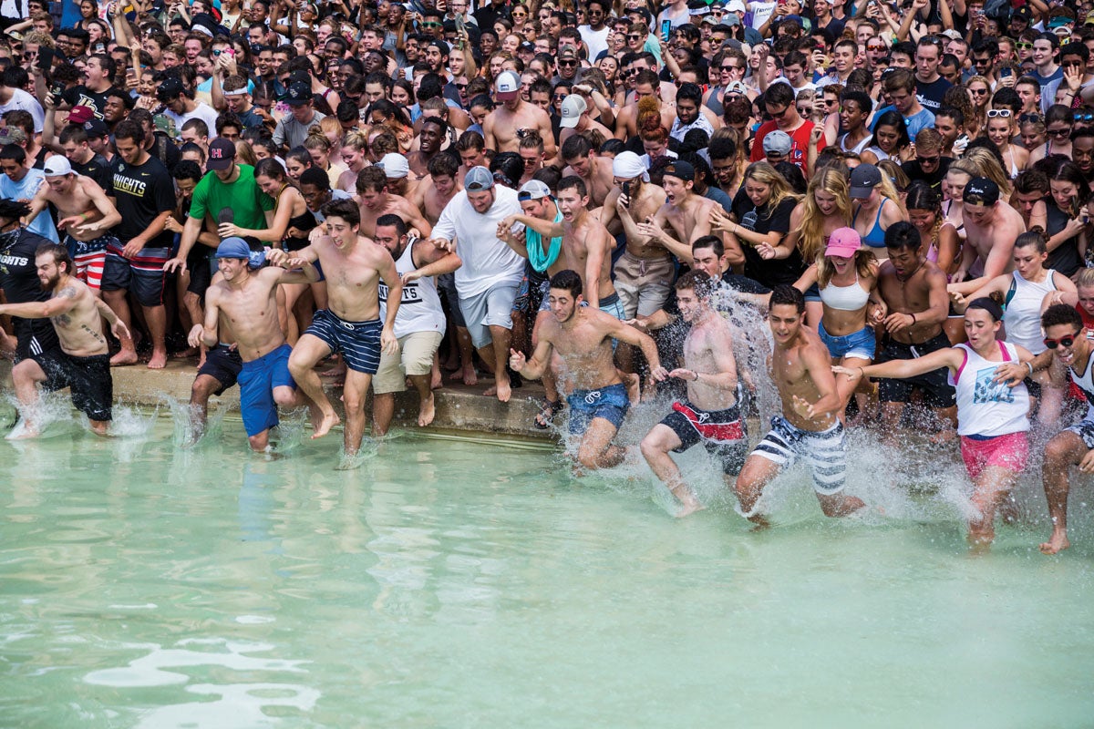 A group of students rush into the water of the Reflecting Pond. A group of students rush into the water of the Reflecting Pond.